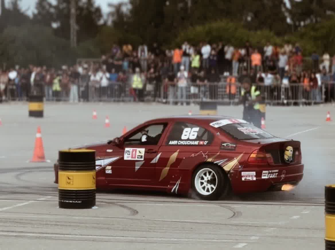 A red car numbered 86 mid-slide, front wheels turned hard into the corner.