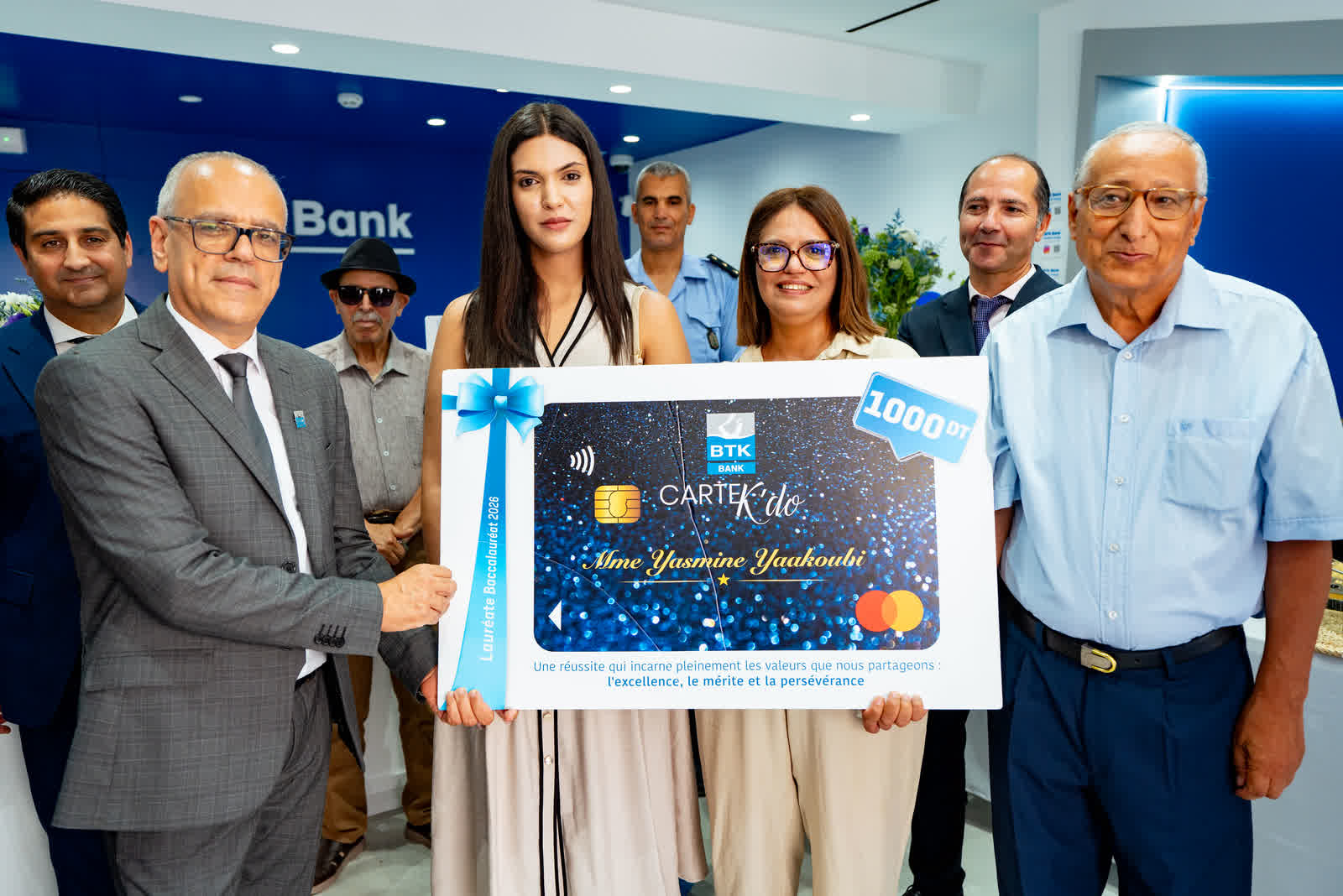 A group holding an oversized presentation card together for the camera.